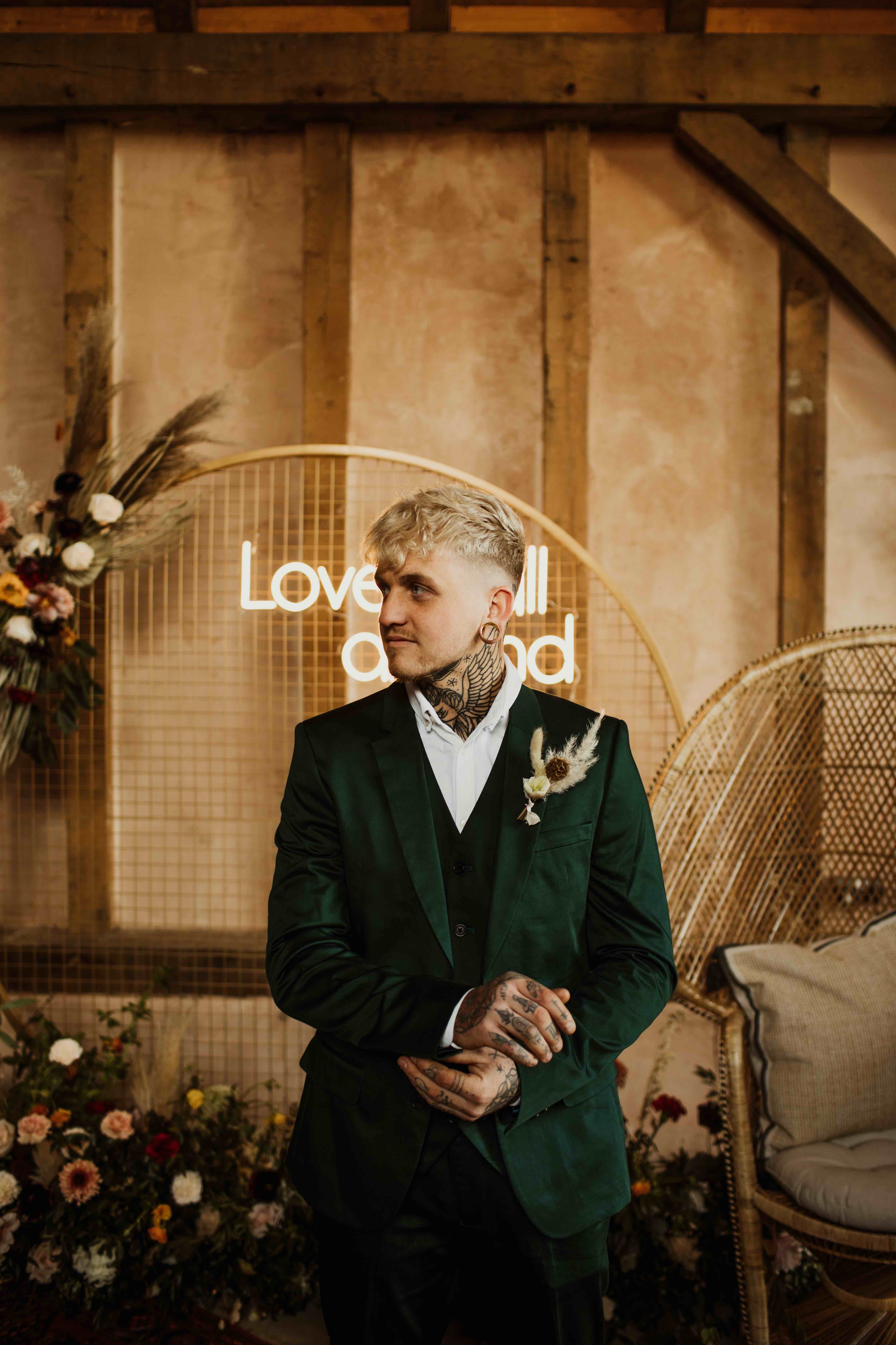 Cool tattooed groom in forest green suit