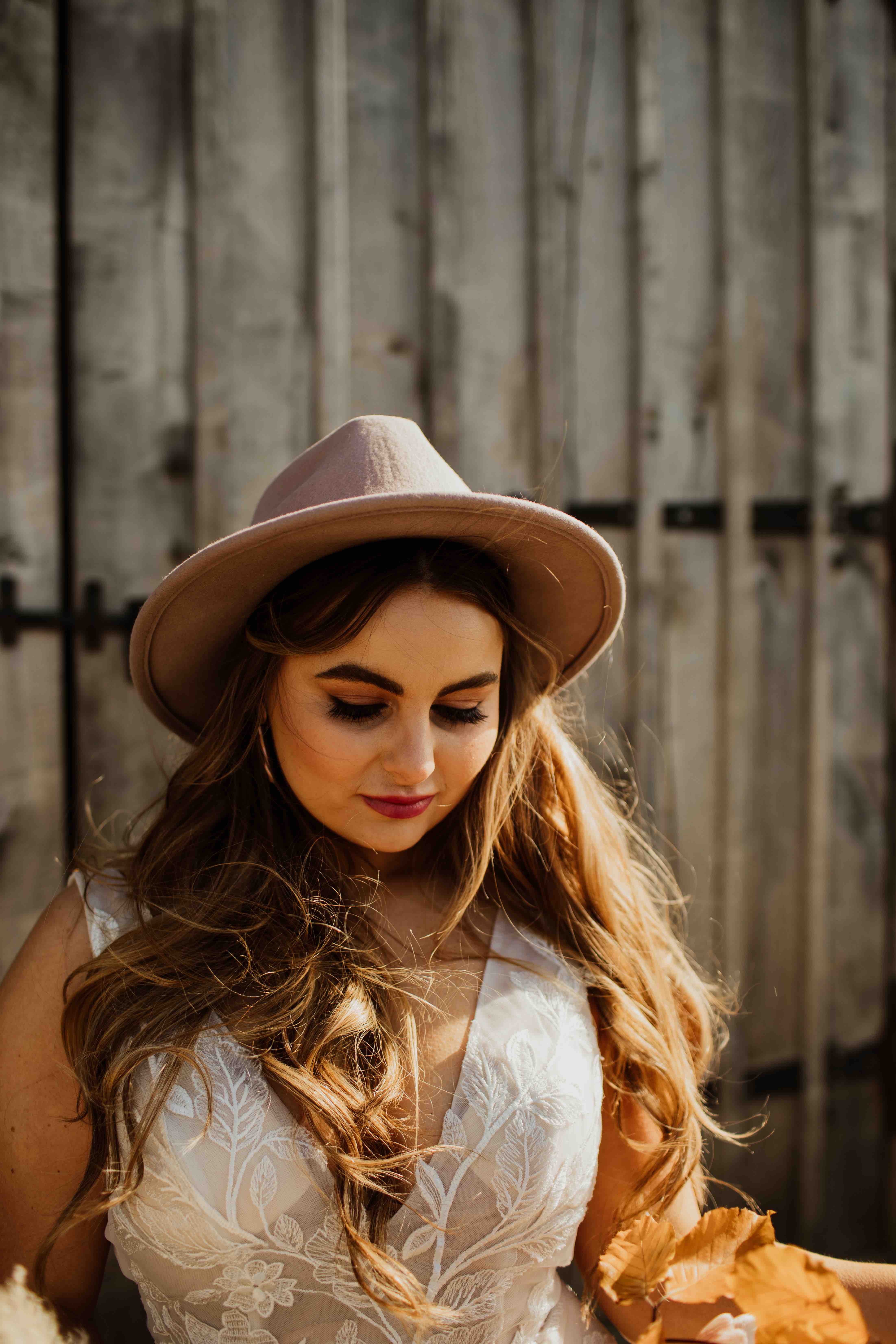  Modern, confident, boho bride with long hair and blush pink hat