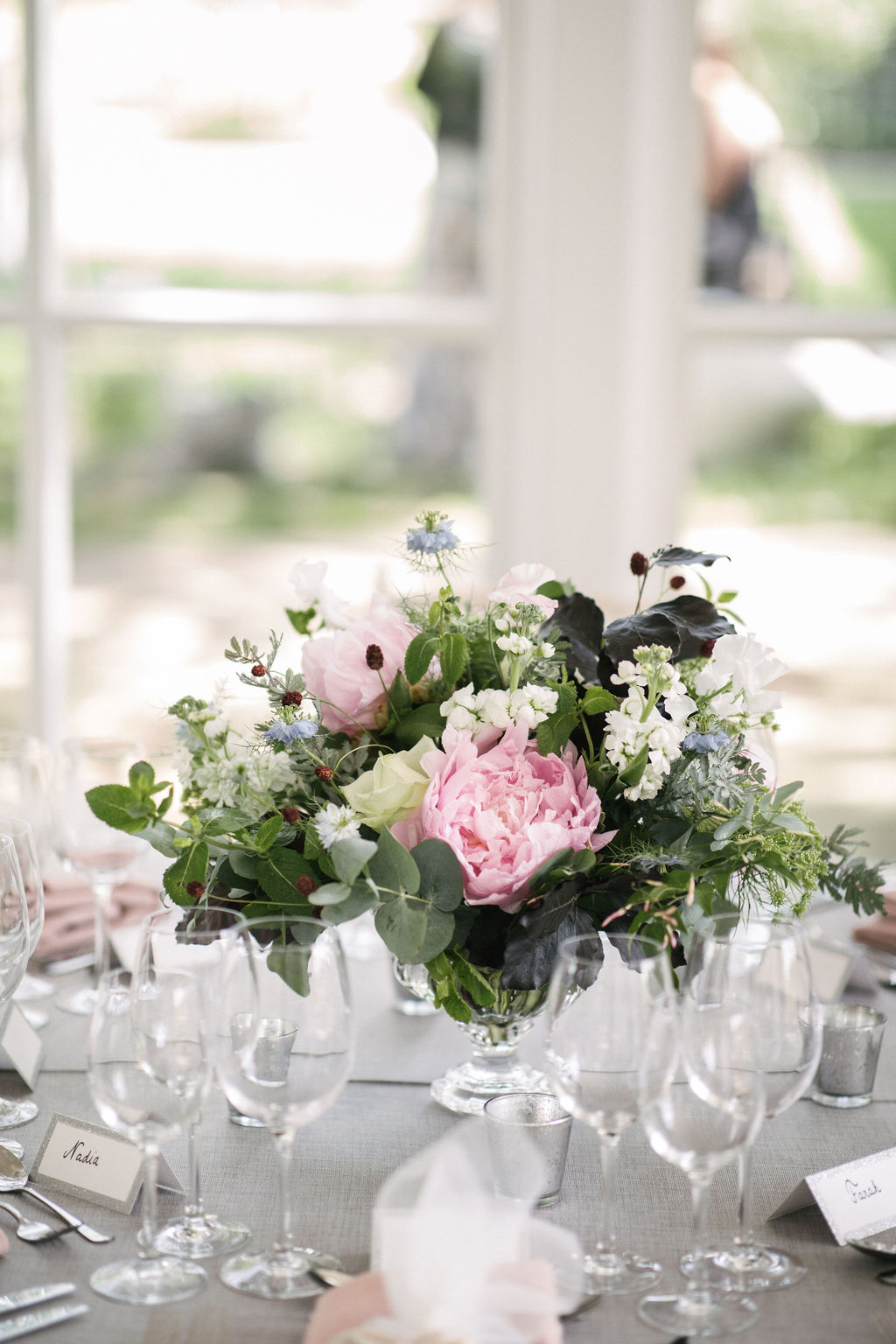 Wedding table centrepiece with pretty pink peonies at The Orangery, Holland Park, London. Photo by Kari Bellamy