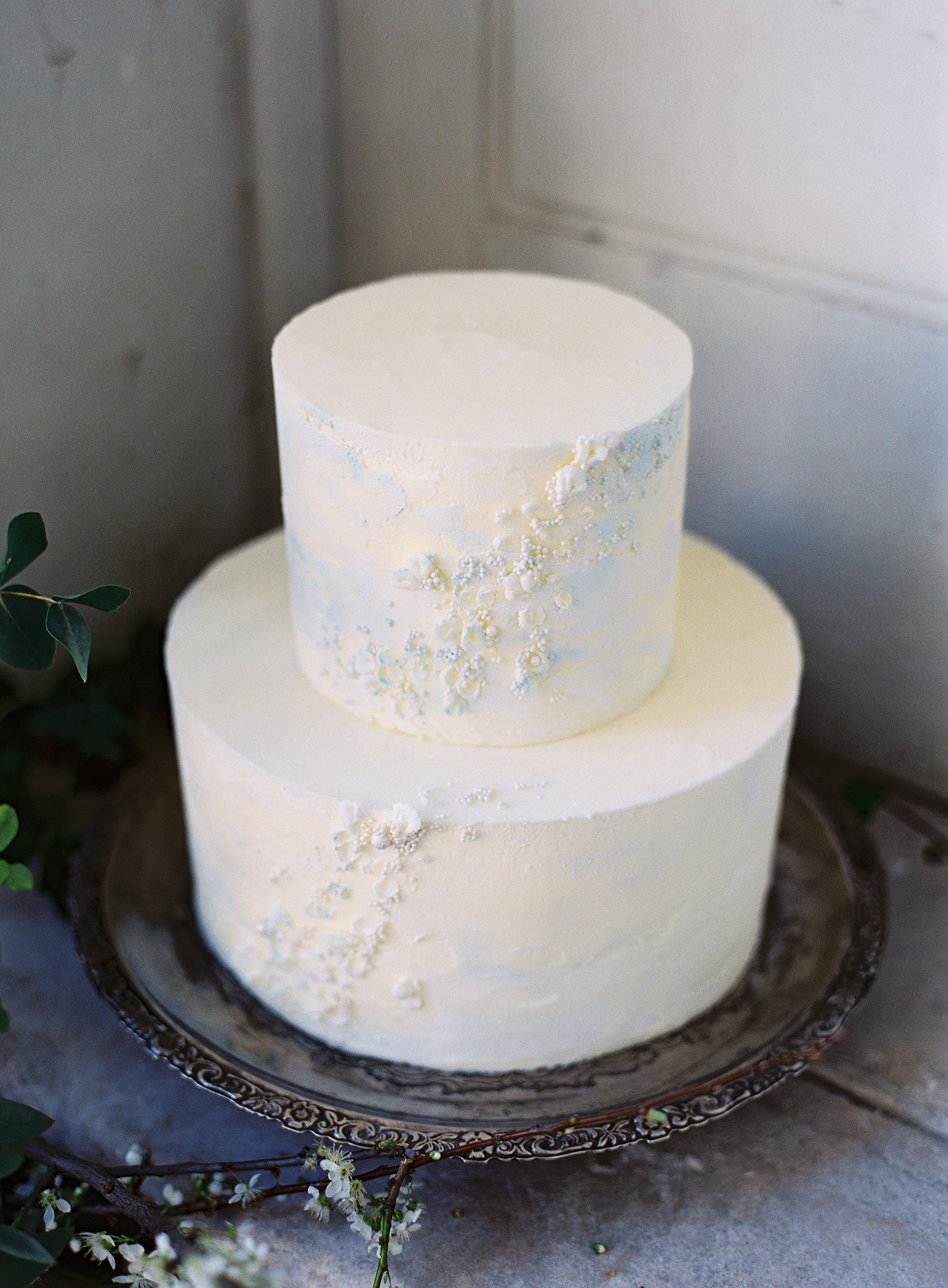 Butterceam cake with romantic textural details for a Spring wedding inspiration shoot at Somerley House. Photo by Camilla Arnhold