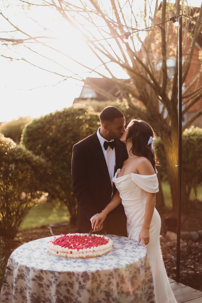 Couple cutting millefoglie wedding cake topped with fresh raspberries